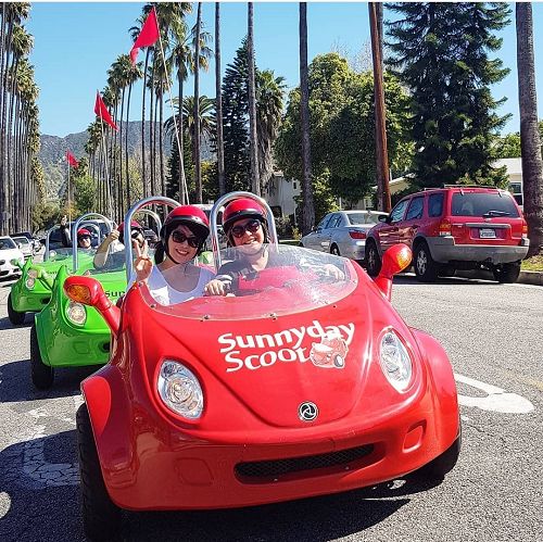 a sunny day scoot minicar with smiling people having fun in LA